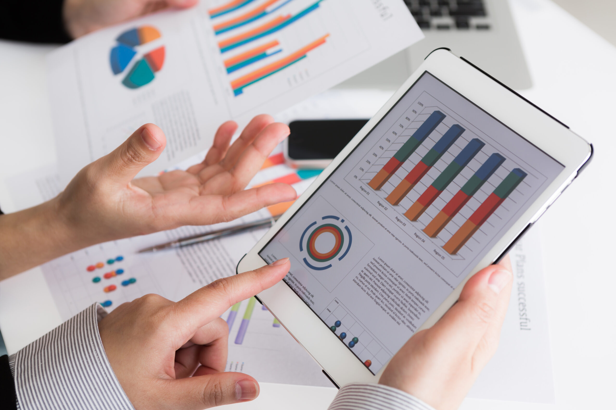 Close-up of business team using digital tablet with financial d